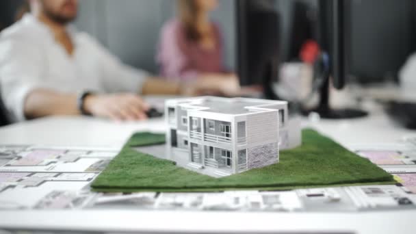 Empresario firma contrato detrás del modelo arquitectónico de la casa. De cerca. 4k — Vídeos de Stock