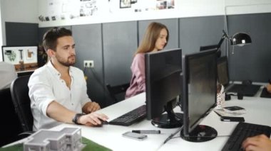 Meşgul tasarım ofis masaları işçi ile geniş açı bakış. 20'li yaşlarda 4 k.