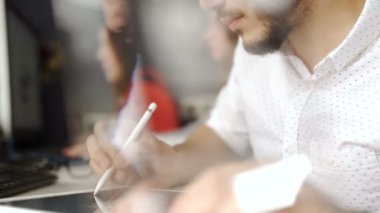 İnteraktif kalem ekran, dijital çizim tablet ve kalem ile bir bilgisayarda çalışan grafik tasarımcı. Arka ışık lensflare ile 20'li yaşlarda 4 k vurdu.