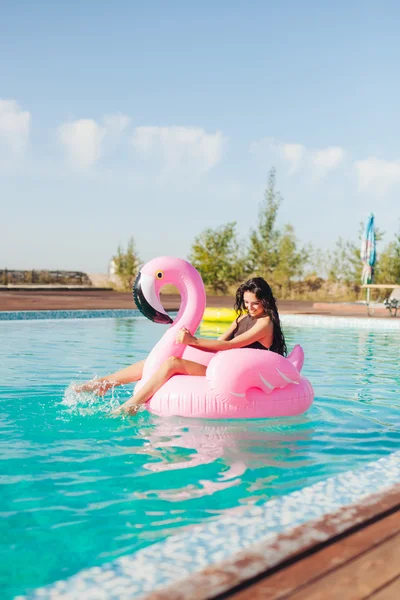 Meisje zit op opblaasbare matras flamingo — Stockfoto