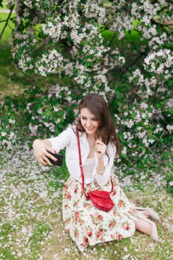 genç kadın selfie açık almak için bir cep telefonu kullanarak. 