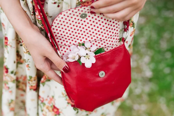 Closeup red bag in hands of woman on the street