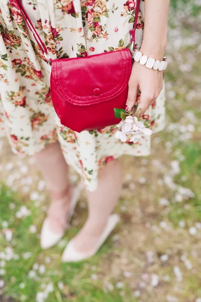 Nahaufnahme rote Tasche in den Händen einer Frau auf der Straße — Stockfoto