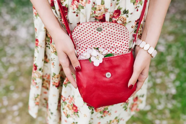 Nahaufnahme rote Tasche in den Händen einer Frau auf der Straße — Stockfoto