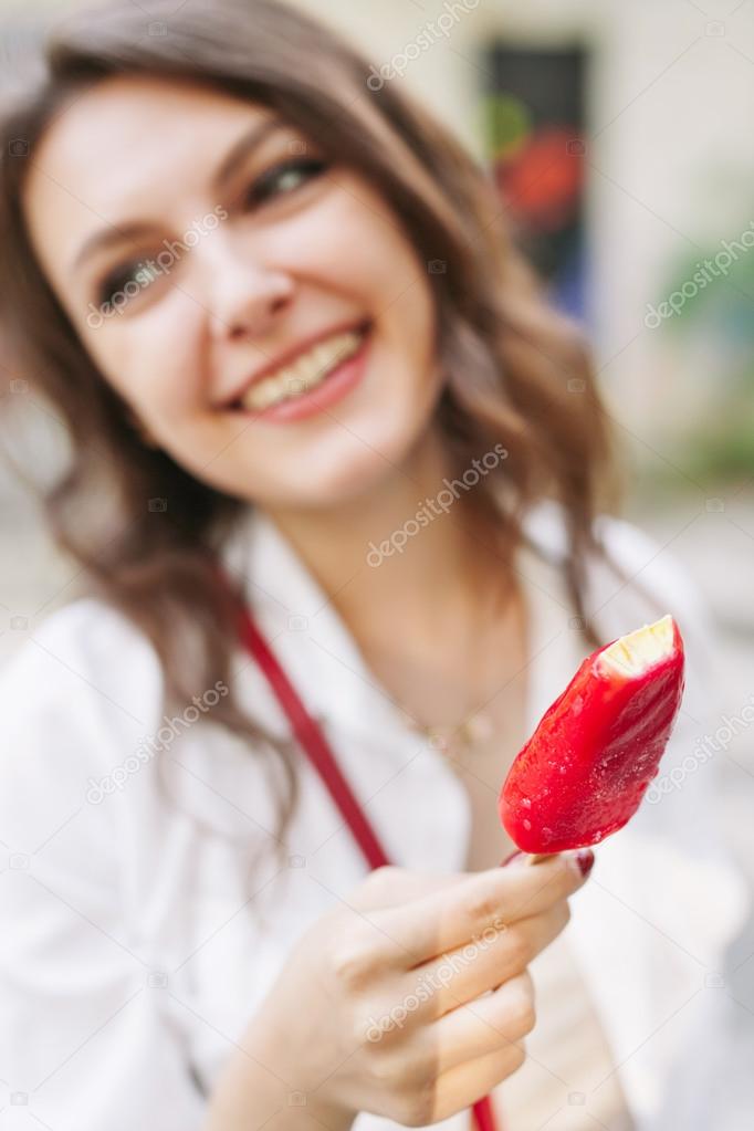 Outdoor closeup portrait of girl eating ice cream in summer 