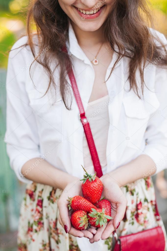 woman holding a bunch of strawberries