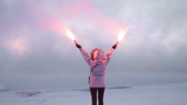 Kvinna med signal bränder på isiga kusten — Stockvideo