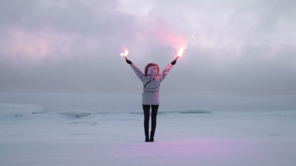 Mulher com fogos de sinal na costa gelada — Vídeo de Stock