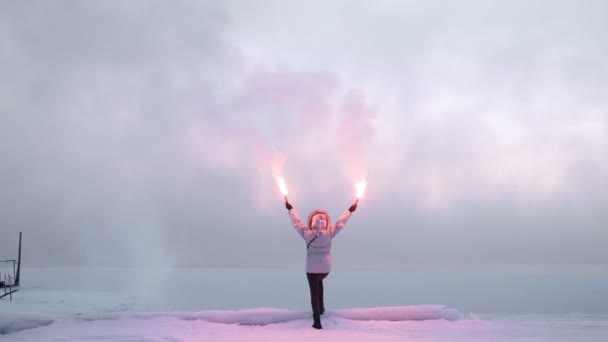 Mulher com fogos de sinal na costa gelada — Vídeo de Stock