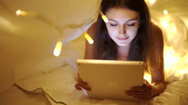 Kız Yatak odasında dijital tablet ile