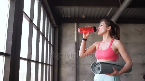 Frau trinkt Wasser in Turnhalle — Stockvideo