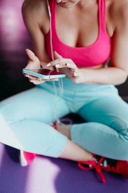 spor salonunda Smartphone kullanan kadın