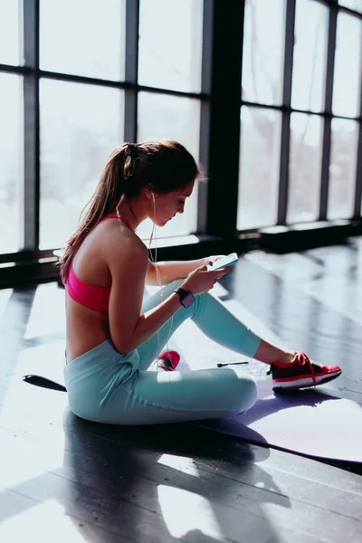 Woman using smartphone at gym — Stock Photo, Image