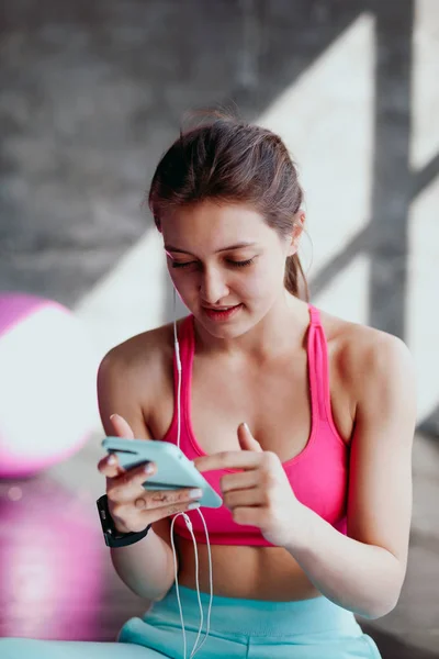 woman using smartphone at gym