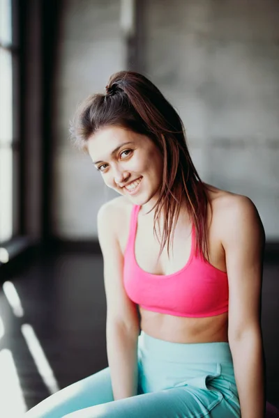 Pretty sporty girl sitting in gym — Stock Photo, Image