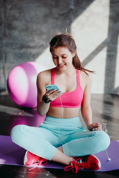 woman at gym using mobile phone