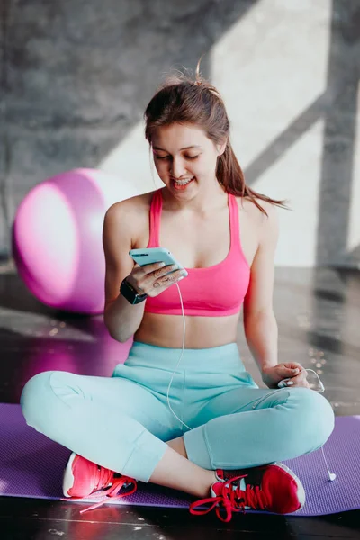 woman at gym using mobile phone