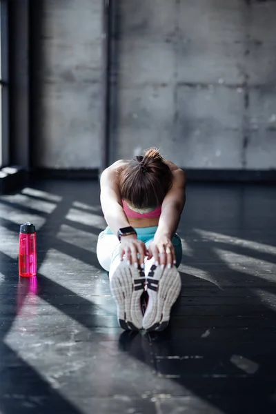 Teenage girl stretching in gym — Stock Photo, Image