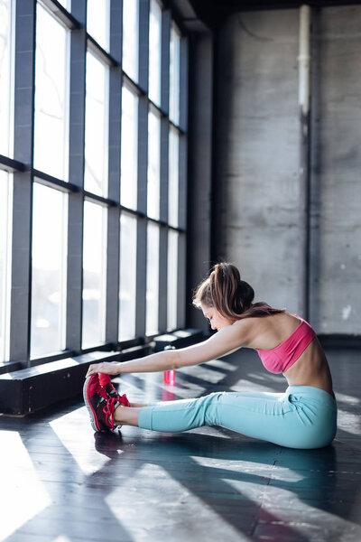teenage girl stretching in gym
