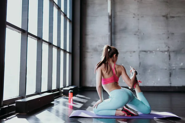 Idrottsman flicka stretching på matta — Stockfoto