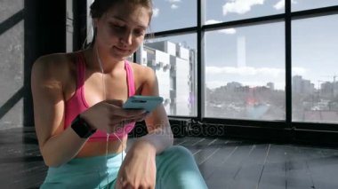 Spor salonunda Smartphone kullanan kadın