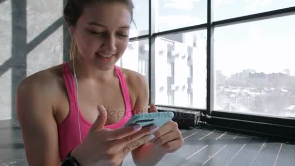 Spor salonunda Smartphone kullanan kadın — Stok video