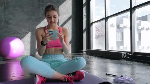 在健身房中使用智能手机的女人 — 图库视频影像