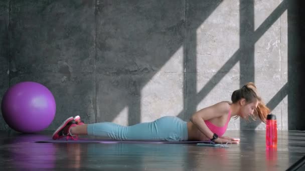 Spor kıyafetli kadın esneme hareketleri yapıyor. — Stok video