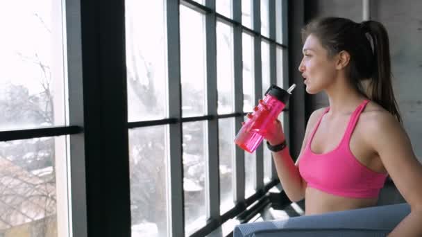 Fitness mujer beber agua de la botella — Vídeos de Stock