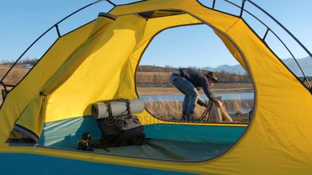 Natt camping. Charmiga par turister sitter ansikte mot ansikte framför tältet nära lägerelden under skiner stjärnklara sky.20s 4k — Stockvideo