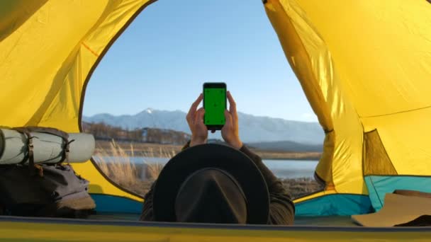 Le panneau solaire fixé à la tente. L'homme assis à côté des frais de téléphone mobile du soleil 20s 4k — Video