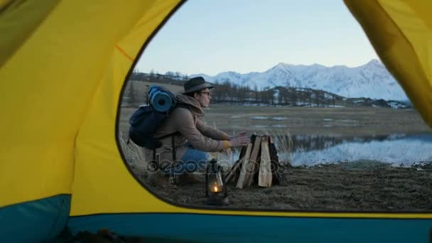Gece kamp. Yüz yüze önünde çadır kamp ateşi yakınındaki parlar yıldızlı gökyüzü altında oturan çekici çifti turistler. 20'li yaşlarda 4 k — Stok video