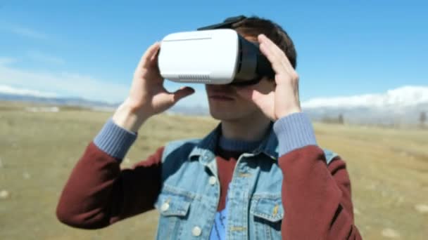 Uomo in 360Vr Casco presso la riva del lago cammina lontano. Giovane uomo in parco al paesaggio autunnale Guarda il video 360 gradi in realtà virtuale auricolare, giocare virtuale 360 vr giochi in vr occhiali 20s 4k — Video Stock