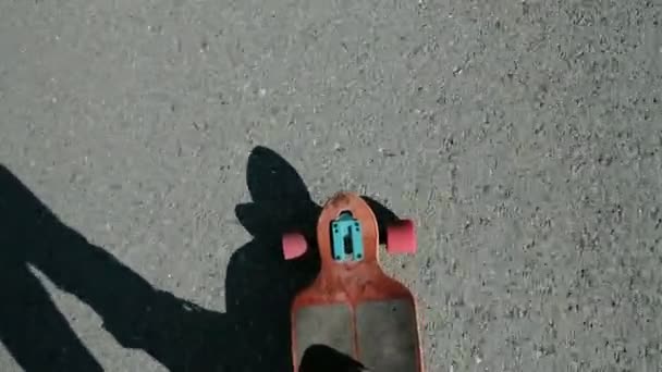 Man riding a longboard, a plan view on the move, close-up, first-person view. Lens, flare effect 20s 4k — Stock Video
