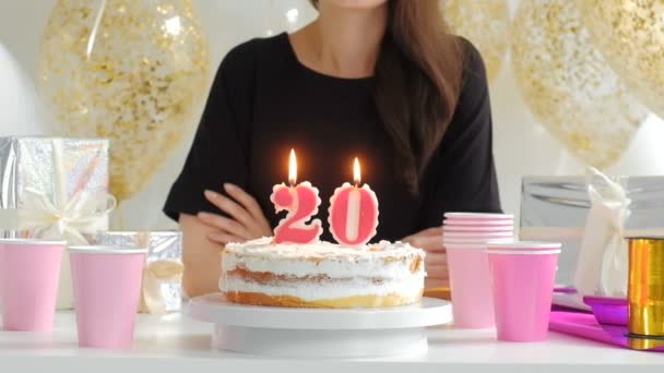 Hermosa joven con pastel de cumpleaños y globos contra luces desenfocadas 1080p fullHD . — Vídeo de stock