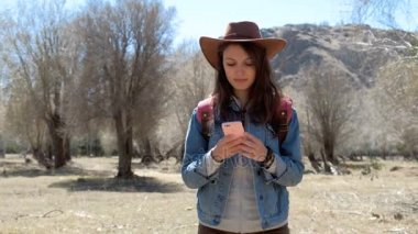 kadın dağ çayır üstünde hareket eden telefon ile