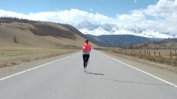 Žena běží na otevřené silnici — Stock video