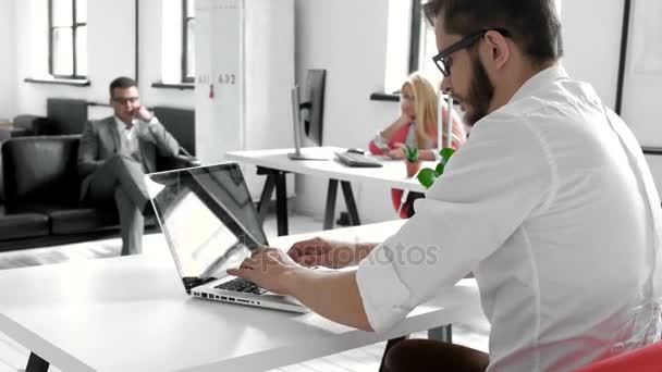 Uppstart team på jobbet. Stora öppna utrymmet office, bärbara datorer och pappersarbete. Affärsidé. Film effekt och linsen flare effekt, suddiga bakgrunden 20s 4 k — Stockvideo