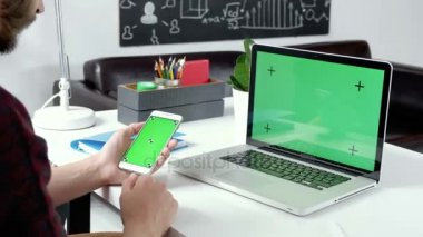 Yeşil ekranlı akıllı telefon holding adam eller yukarı kapatın. Chroma Key. Erkek el ile cep telefonu resimleri kaydırma kapatın. 20'li yaşlarda 4 k iş grafik arka plan