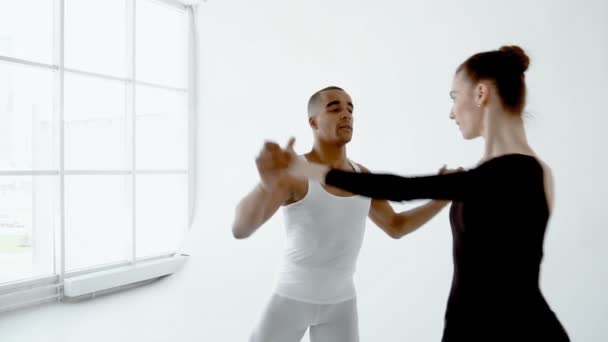 Un par de bailarines de ballet bailan maravillosamente sobre el fondo de una gran ventana de cierre en cámara lenta 120fps . — Vídeo de stock