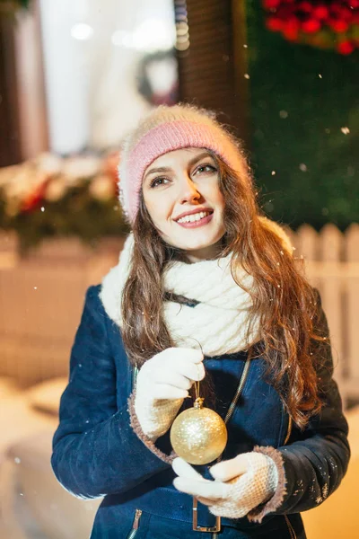 Woman  holding a Christmas gold ball. — Stock Photo, Image