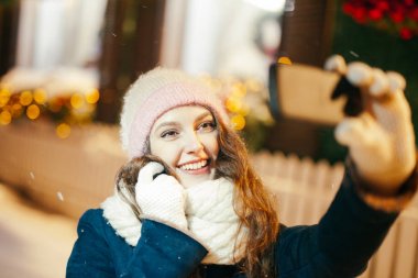 Akıllı telefon kullanan genç bir kadın.  