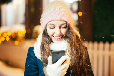 Akıllı telefon kullanan genç bir kadın.  