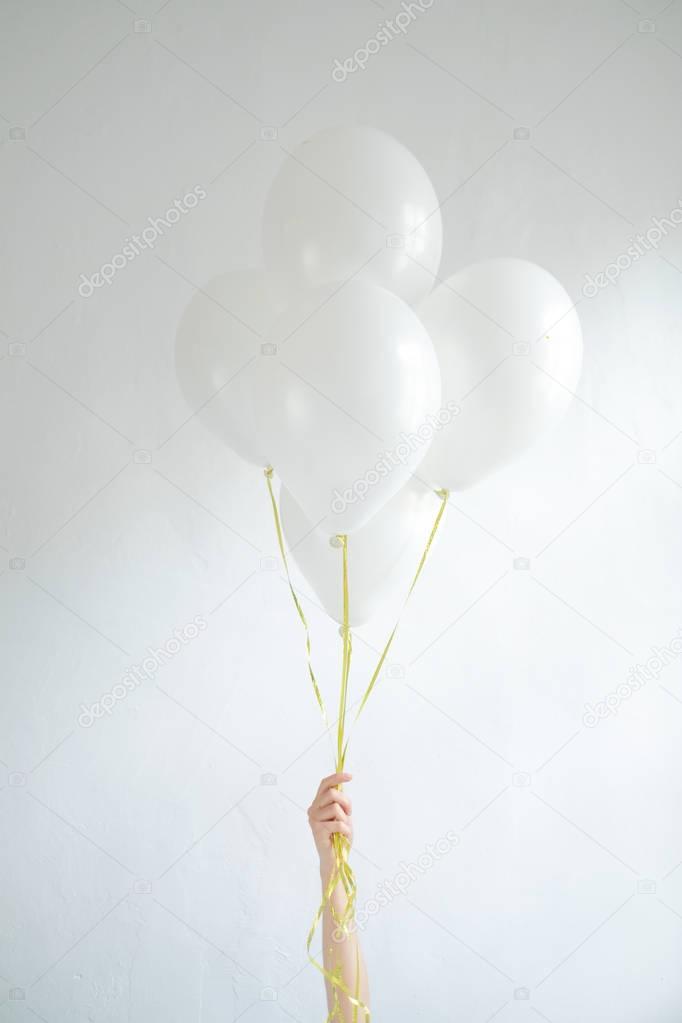 Hand holding  blank white balloons