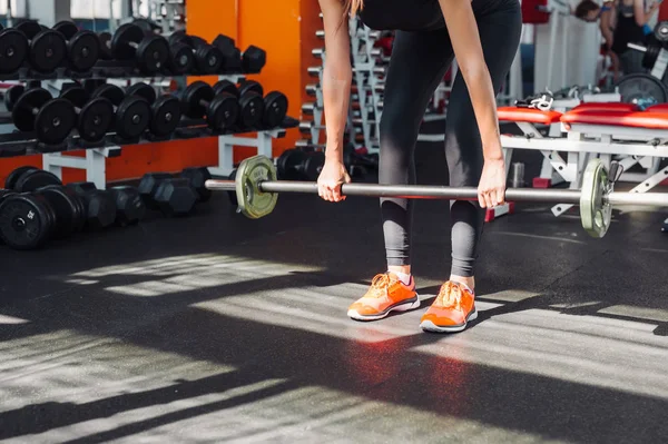 Kvinnan gör shoulder press övning med vikt bar i gymmet — Stockfoto