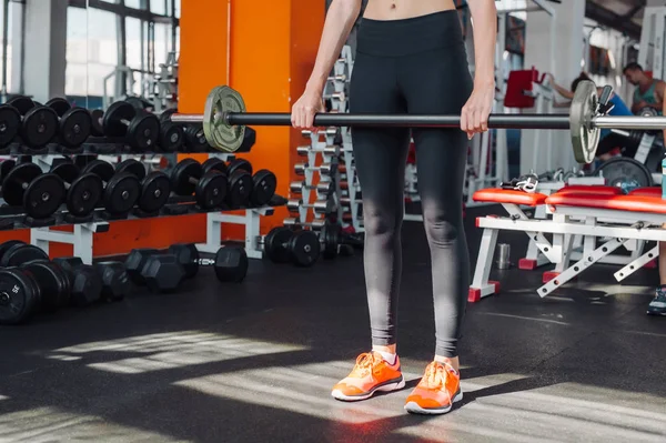 Kvinnan gör shoulder press övning med vikt bar i gymmet — Stockfoto