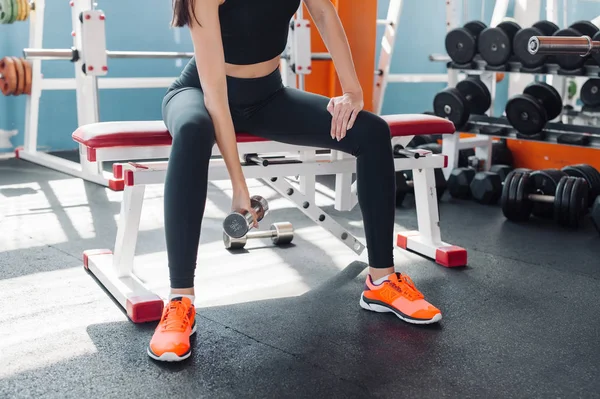 Passar kvinna 20s gör axel höjer med hantlar i gymmet — Stockfoto