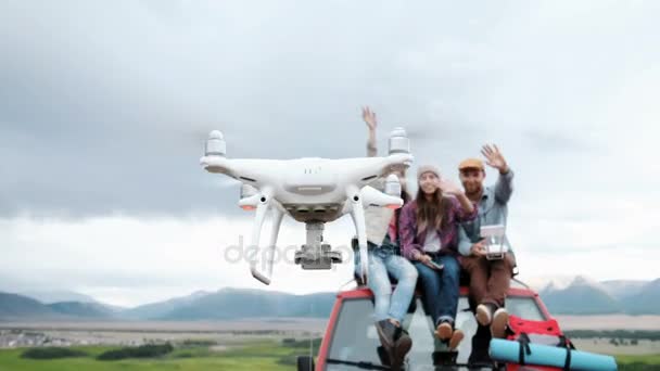 Grupo de amigos haciendo selfie en drone sentado en coche rojo en fondo de montaña 20s 4k — Vídeos de Stock