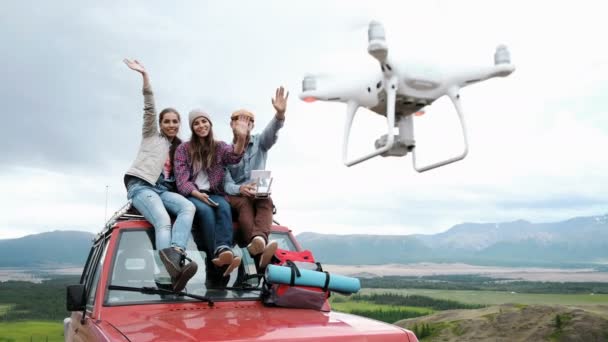 Ezzel a drone a piros autó a hegyi háttér háttér 20s 4 k ül selfie baráti. — Stock videók