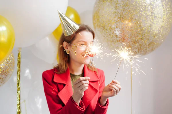 Jovem mulher segurando sparklers — Fotografia de Stock